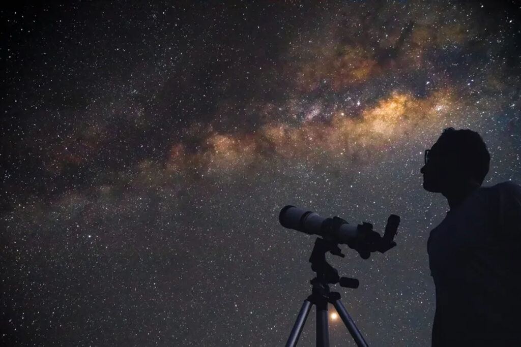 Astronomer observing the night sky through a telescope